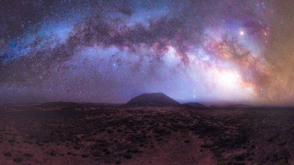 Vivid Milky Way arching over a volcanic landscape, representing the sidereal star positions used in Vedic astrology