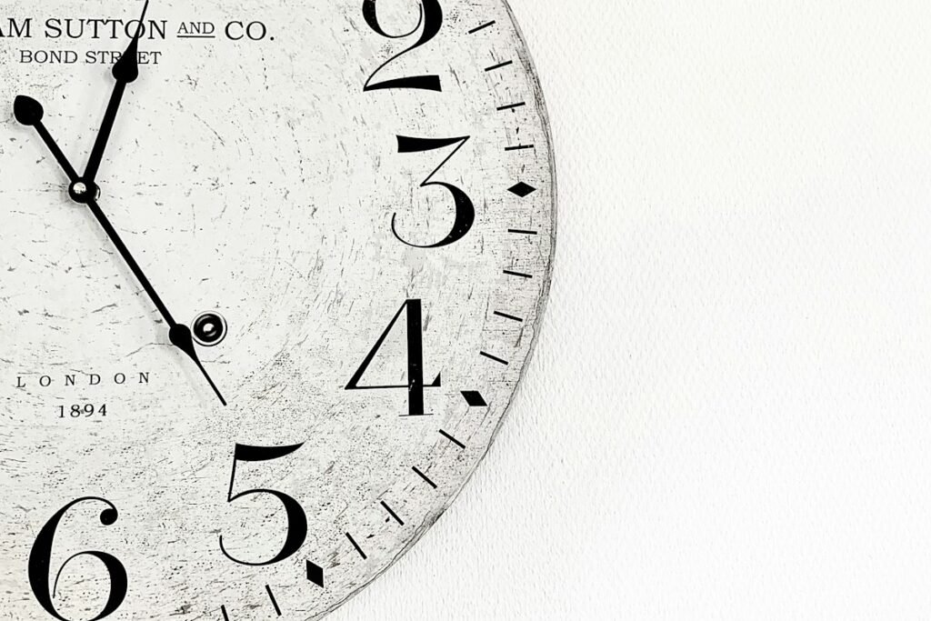 How Long Should a Vedic Astrology Report Take to Deliver? 2 Analog wall clock on a pale wall, marking the astrology report delivery time window