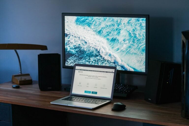 Laptop and monitor on a wooden desk, where a free kundli calculator is typically used